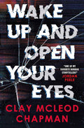 Paperback copy of "Wake Up and Open Your Eyes" supernatural horror novel by Clay McLeod Chapman, showing the book cover with dark, eerie artwork.