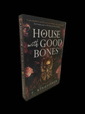 Paperback of "A House with Good Bones" by T. Kingfisher, featuring a cozy house illustration on the cover.